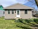 Charming home featuring vinyl siding, a well-manicured lawn, and blooming plants adding curb appeal at 1136 Lawrence Ave, Indianapolis, IN 46227