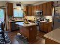Charming kitchen features oak cabinets, stainless steel appliances, an island, and decorative tile backsplash at 11786 Ledgestone Cir, Fishers, IN 46037