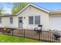 Quaint front porch with decorative black fencing, potted flowers, and a welcoming chair at 1213 Fairview Dr, Greenfield, IN 46140