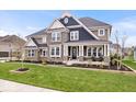Attractive two-story home featuring stone accents, a charming front porch, and beautifully maintained landscaping at 1352 Trifecta Way, Westfield, IN 46074