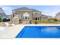 Inviting backyard pool with stamped concrete patio, outdoor stone fireplace, and meticulously maintained landscaping at 1352 Trifecta Way, Westfield, IN 46074