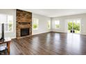 Bright living room featuring a stone fireplace, hardwood floors, and sliding doors to the backyard at 13567 Moorcroft Dr, Fishers, IN 46037