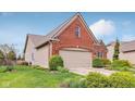 Charming brick home with a manicured lawn, mature landscaping, and a welcoming two-car garage at 1361 Trescott Dr, Westfield, IN 46074