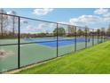 Exterior view of a fenced-in tennis court with a green and blue playing surface and well-maintained grass at 1361 Trescott Dr, Westfield, IN 46074
