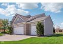 Spacious three-car garage with gray vinyl siding and brick accents at 14323 Chariots Whisper Dr, Carmel, IN 46074