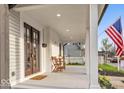 Inviting front porch features seating, dark wood doors, and a charming exterior at 15 N Campbell Ave, Indianapolis, IN 46219