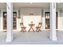 Inviting front porch features seating, dark wood doors, and a charming exterior at 15 N Campbell Ave, Indianapolis, IN 46219