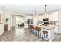 Spacious kitchen with white cabinetry, stainless steel appliances, a large island, and adjacent dining area at 17066 Cole Evans Dr, Noblesville, IN 46060