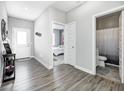 This hallway has doors to a bathroom and bedroom, and features modern grey walls and wood-look floors at 238 Switchgrass Ln, New Whiteland, IN 46184