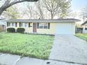 Inviting one-story home featuring a garage and tidy front lawn, perfect for a new homeowner at 2465 N Eaton Ave, Indianapolis, IN 46219