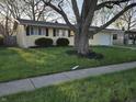 Well-manicured front yard with lawn and flower bed accentuates this ranch style home at 2465 N Eaton Ave, Indianapolis, IN 46219