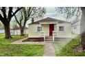 Home featuring a covered porch, red front door, and a walkway leading to the entrance at 3136 Foltz St, Indianapolis, IN 46221