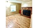 Bright living room featuring wood floors, a brick fireplace, and a large window at 3136 Foltz St, Indianapolis, IN 46221