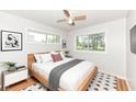 Bright bedroom with a modern bed frame, two windows, and hardwood floors at 319 E Ohio St, Fortville, IN 46040