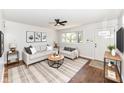 Staged living room with a ceiling fan, comfortable seating, and ample natural light at 319 E Ohio St, Fortville, IN 46040