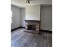 Living room with a brick fireplace, baseboard trim and wood-look flooring at 325 Harlan St, Indianapolis, IN 46201