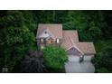 Aerial view of a brick home with mature trees, attached garage, and manicured lawns showcasing its beautiful neighborhood at 4541 Greenthread Ct, Zionsville, IN 46077