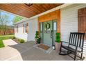 Charming front door with wooden trim, wreath, potted plants, and welcome mat at 4622 W 400 S, Trafalgar, IN 46181