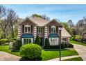 Beautiful brick home featuring lush green lawn and mature trees enhancing the property's appeal at 4731 Moss Creek Ct, Indianapolis, IN 46237
