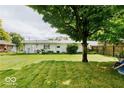 Expansive backyard with lush green grass and mature trees offering shade; perfect for outdoor activities and relaxation at 4916 N Richardt Ave, Indianapolis, IN 46226