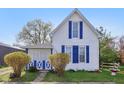A quaint home featuring blue shutters, a covered porch, and mature landscaping at 540 S Broadway St, Atlanta, IN 46031