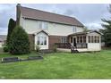 Spacious backyard featuring a covered porch, a deck, and lush green lawn at 5573 Royal Troon Way, Avon, IN 46123
