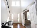 Bright foyer with hardwood floors, staircase, and view into an adjacent room at 5624 Ottawa Pass, Carmel, IN 46033