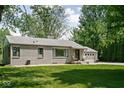 Well-maintained one-story house featuring a gravel driveway, a two-car garage, and mature landscaping at 6223 N Parker Ave, Indianapolis, IN 46220