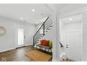 Clean and bright entryway with a staircase, bench seating, and modern design elements at 625 N Temple Ave, Indianapolis, IN 46201