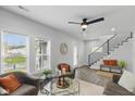 Cozy living area with staircase, large windows, and comfortable seating with bright orange accents at 625 N Temple Ave, Indianapolis, IN 46201