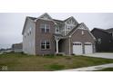Well-maintained two-story home with a brick and siding exterior, spacious lawn, and attached two-car garage at 6304 Frst Brk Dr, Indianapolis, IN 46259