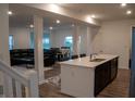 Bright open-concept kitchen with stainless steel appliances, island with sink, and hardwood floors at 6304 Frst Brk Dr, Indianapolis, IN 46259