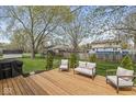 A wooden deck in a spacious backyard that is shaded by mature trees, perfect for outdoor relaxation at 7656 Madden Ln, Fishers, IN 46038