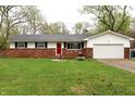 Classic ranch-style home with a brick exterior, attached garage, and well-maintained front lawn at 8017 Chiltern Dr, Indianapolis, IN 46268