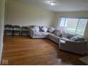 Bright living room features hardwood floors and a comfortable sectional sofa with decorative pillows at 8017 Chiltern Dr, Indianapolis, IN 46268