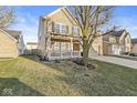 Well-maintained home with a lush lawn, a charming front porch, and a two-car garage at 8327 Andrusia Ln, Indianapolis, IN 46237