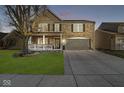 Charming two-story brick home with attached garage, covered porch, and manicured front lawn at 8327 Andrusia Ln, Indianapolis, IN 46237