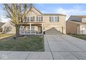 Beautiful two-story brick home showcasing a welcoming front porch and a spacious driveway at 8327 Andrusia Ln, Indianapolis, IN 46237