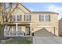 Inviting two-story brick home featuring a charming front porch and an attached two-car garage at 8327 Andrusia Ln, Indianapolis, IN 46237