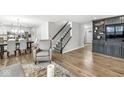 Open-concept living area with wood floors, a staircase, and a view of the dining and kitchen spaces at 8327 Andrusia Ln, Indianapolis, IN 46237