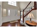 Bright foyer with hardwood floors, elegant staircase, and a large arched window at 9319 Oak Knoll Ln, Fishers, IN 46037
