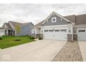 Home with a two-car garage, inviting curb appeal with lush green lawn and young tree at 9455 Orchard Cove Dr, Indianapolis, IN 46239