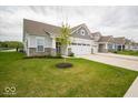 Charming home with a two-car garage, lush green lawn, and beautiful landscaping at 9455 Orchard Cove Dr, Indianapolis, IN 46239