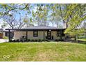 Charming single Gathering home featuring a stone facade, dark trim, and a well manicured lawn at 9944 Holaday Dr, Carmel, IN 46032