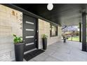 Inviting front porch showcases modern black door, sconce lighting, and tile flooring at 9944 Holaday Dr, Carmel, IN 46032