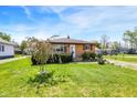 Inviting single-story brick home with fresh green lawn and mature tree at 1043 E Castle Ave, Indianapolis, IN 46227