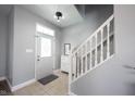Bright entryway featuring tile floors, a staircase, shoe storage and stylish decor at 11327 Guy St, Fishers, IN 46038