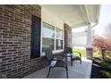 Close up of a front porch with brick columns and seating in front of a large window at 11327 Guy St, Fishers, IN 46038