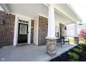 Charming front porch with brick columns, comfortable seating, and decorative landscaping at 11327 Guy St, Fishers, IN 46038