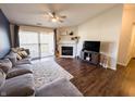 Bright living room with a ceiling fan, a cozy fireplace, access to a balcony, and a comfortable sofa at 12517 Timber Creek Dr # 10, Carmel, IN 46032